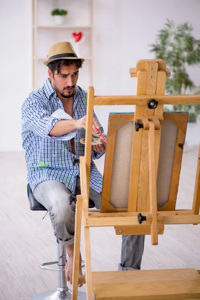 Молодой человек наслаждается живописью в студии — стоковое фото