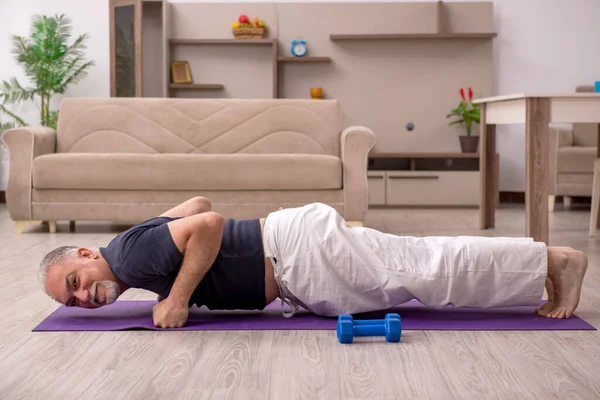 Velho fazendo exercícios esportivos em casa — Fotografia de Stock