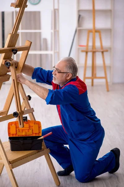 Oude mannelijke timmerman repareert schildersezel — Stockfoto