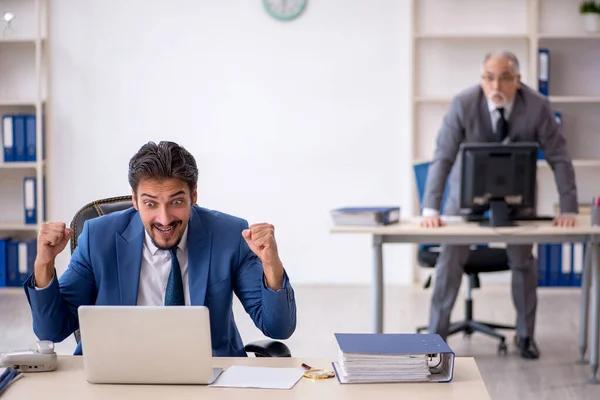 Viejo jefe y joven empleado masculino que trabaja en la oficina —  Fotos de Stock