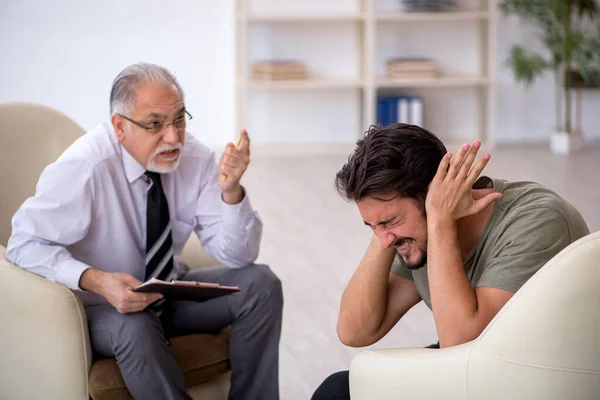 Young man visiting old psychologist — Stock Photo, Image
