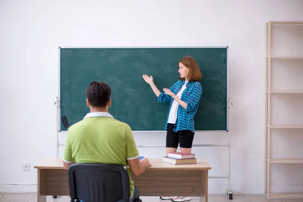 Jonge leraar en student in de klas — Stockfoto