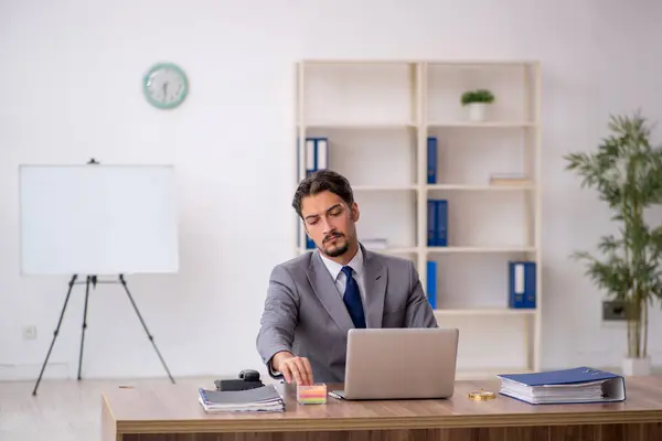 Jeune employé masculin assis dans le bureau — Photo