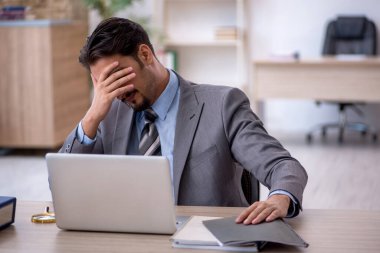 Ofiste çalışan genç bir erkek.