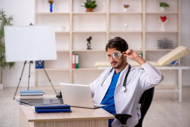 Klinikte çalışan genç erkek doktor.