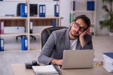 Ofiste çalışan genç bir erkek.