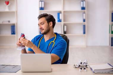 Klinikte çalışan genç bir erkek kardiyolog.
