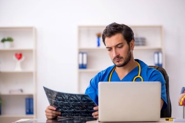 Klinikte çalışan genç bir erkek radyolog.