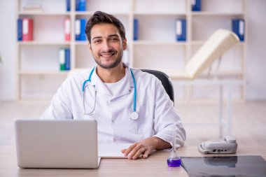 Klinikte çalışan genç erkek doktor.