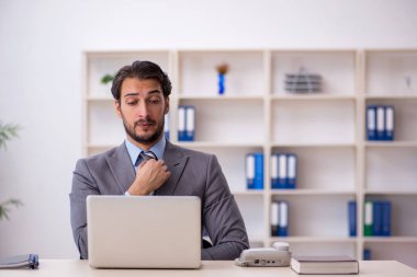 Ofiste çalışan genç bir erkek.