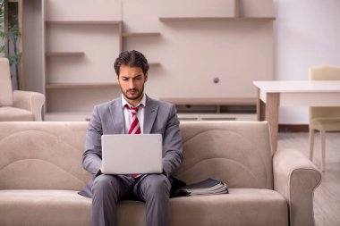 Genç erkek çalışan salgın sırasında evden çalışıyor.