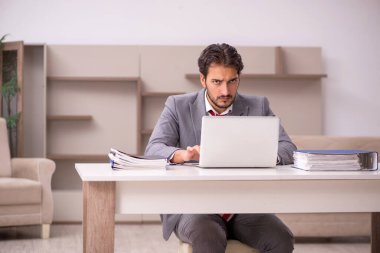 Genç erkek çalışan salgın sırasında evden çalışıyor.