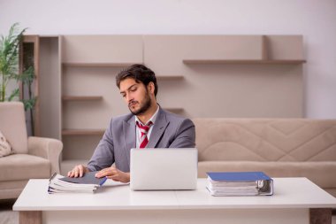 Genç erkek çalışan salgın sırasında evden çalışıyor.