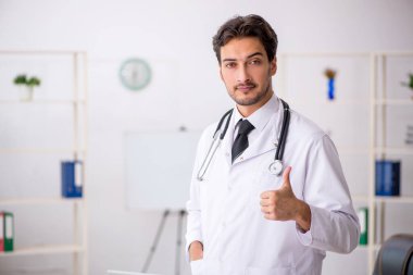 Klinikte çalışan genç erkek doktor.