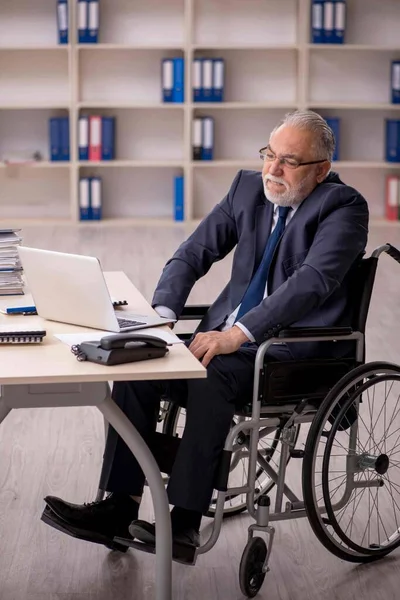 A munkahelyen ülő kerekesszékes idős férfi alkalmazott — Stock Fotó