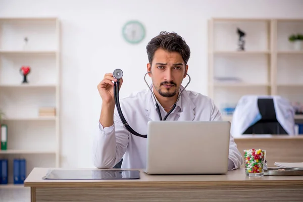 Ung manlig läkare som arbetar på kliniken — Stockfoto