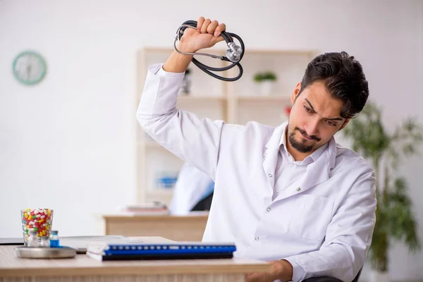 Ung manlig läkare som arbetar på kliniken — Stockfoto