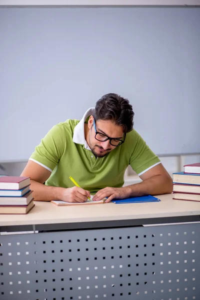 Joven estudiante masculino preparándose para los exámenes en el aula — Foto de Stock