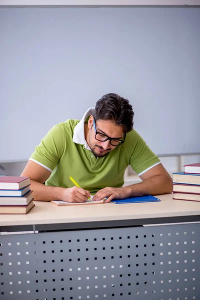 Giovane studente maschio che si prepara per gli esami in classe — Foto Stock