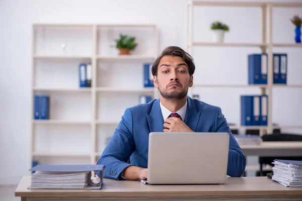 Joven empleado masculino y demasiado trabajo en la oficina —  Fotos de Stock