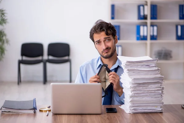 Joven empleado masculino y demasiado trabajo en la oficina — Foto de Stock