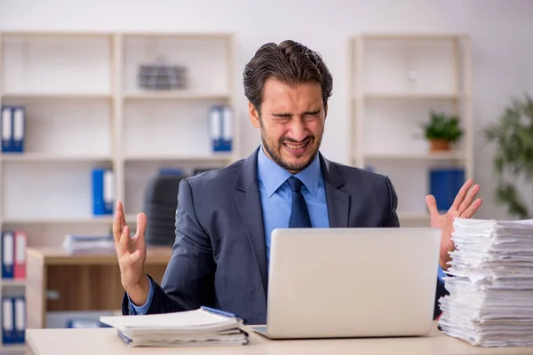 Giovane dipendente maschio e troppo lavoro in ufficio — Foto Stock