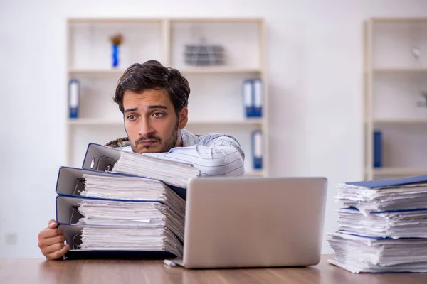 Joven empleado masculino descontento con el trabajo excesivo en la oficina — Foto de Stock