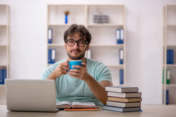 Jonge mannelijke student bereidt zich voor op examens in de klas — Stockfoto