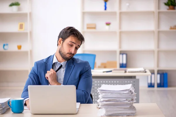 Jonge mannelijke werknemer en te veel werk op kantoor — Stockfoto