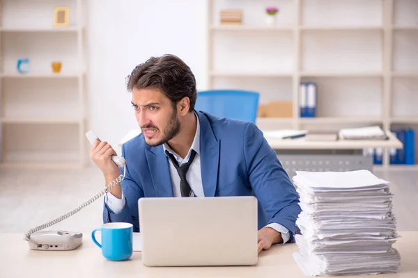 Jeune employé masculin et trop de travail au bureau — Photo