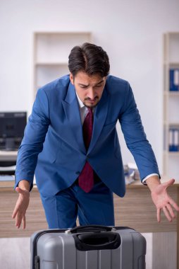 Genç bir erkek işçi iş yerinde geziye hazırlanıyor.