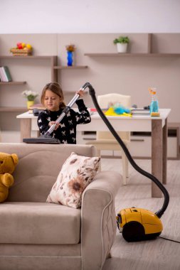 Küçük kız evde ev işi yapıyor.