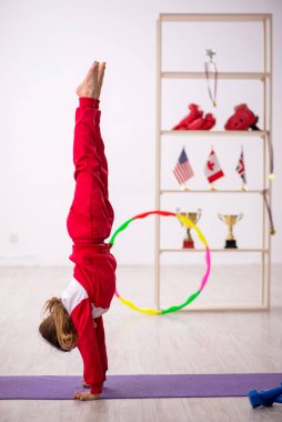 Küçük kız evde spor yapıyor.