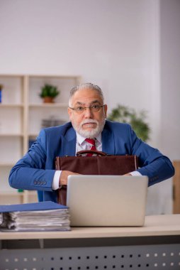 Ofiste çalışan yaşlı bir erkek.