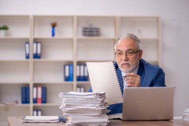 Ofiste çalışan yaşlı bir erkek.