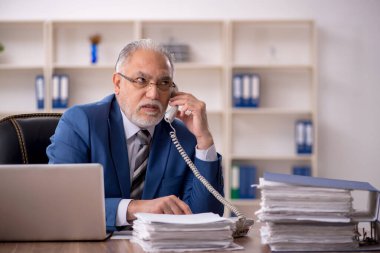 Ofiste çalışan yaşlı bir erkek.