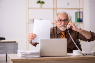 İş yerinde çalışan yaşlı bir erkek işçi.