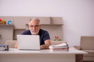 Salgın sırasında evde çalışan yaşlı bir erkek işçi.