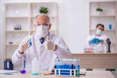 Laboratuvarda çalışan iki erkek kimyager.