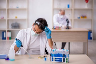 Laboratuvarda çalışan iki erkek kimyager.