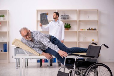 Yaşlı adam genç erkek doktor radyolojisti ziyaret ediyor.