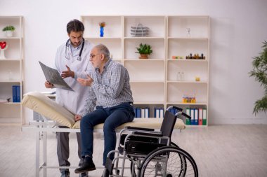 Yaşlı adam genç erkek doktor radyolojisti ziyaret ediyor.