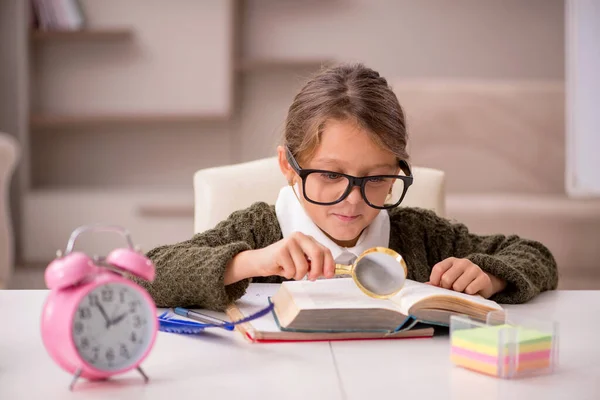 Маленькая девочка учится дома по концепции управления временем — стоковое фото