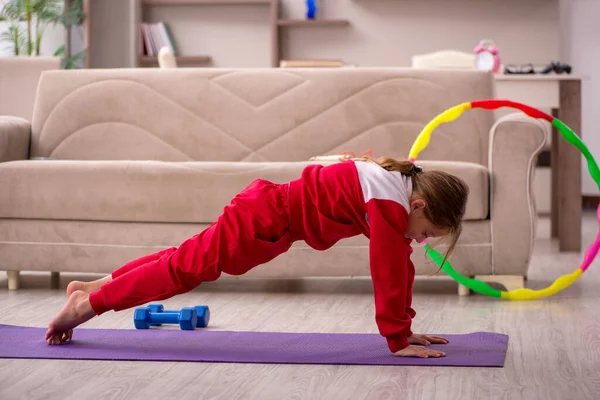 Küçük kız evde spor yapıyor. — Stok fotoğraf