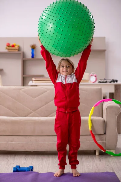 Ung liten flicka gör sport övningar hemma — Stockfoto