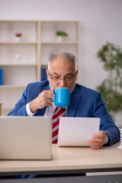 Старый мужчина пьет кофе во время перерыва — стоковое фото