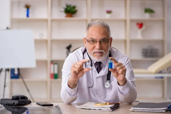 Gammal manlig läkare som arbetar på kliniken — Stockfoto