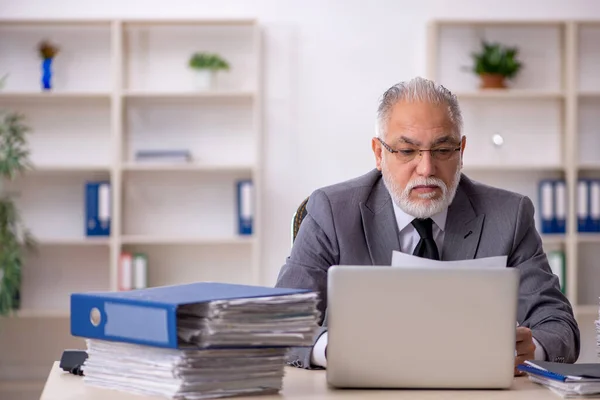 Velho empregado masculino e muito trabalho no escritório — Fotografia de Stock