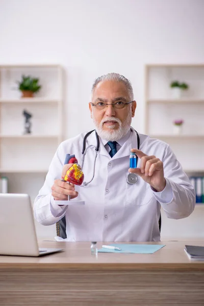 Gammal manlig läkare kardiolog arbetar på kliniken — Stockfoto