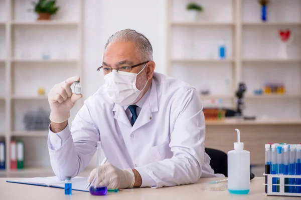 Oude mannelijke chemicus werkt in het lab. — Stockfoto